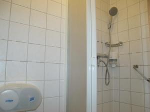 ein Bad mit einer Dusche mit einem Duschkopf in der Unterkunft Zorn Hotel Duinlust in Noordwijk aan Zee