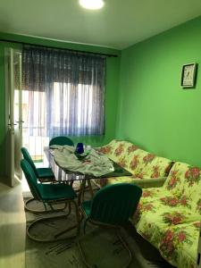 um quarto com uma mesa e cadeiras e uma parede verde em Nestorovski House em Bitola