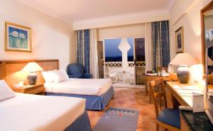 Un pat sau paturi într-o cameră la Old Palace Resort Sahl Hasheesh