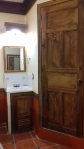 a bathroom with a wooden door and a sink at Hotel Tradicional in San Cristóbal de Las Casas