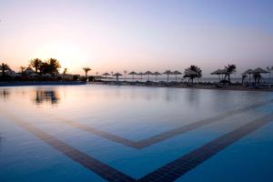 a swimming pool at a resort with umbrellas at Old Palace Resort Sahl Hasheesh in Hurghada