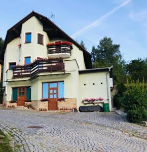 a large white house with a black roof at Ubytování na Lesní in Luhačovice