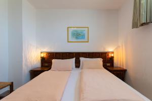 una camera da letto con un letto grande con due cuscini bianchi di Apartamentos Melusina en Playa del Inglés al lado de la playa y las Dunas de Maspalomas a Playa del Ingles Altre 34 foto