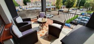 een balkon met stoelen en een tafel en uitzicht op een straat bij Apartament Eve in Giżycko