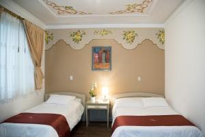 En eller flere senge i et værelse på Hotel La Orquidea