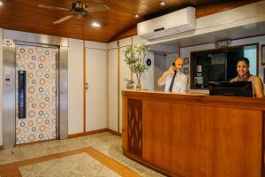 a man talking on a cell phone at a reception desk at Infinity Copacabana, Ex-APA Hotel in Rio de Janeiro