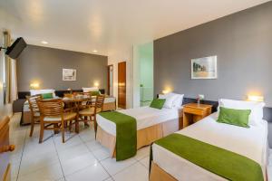 a hotel room with two beds and a dining room at Infinity Copacabana in Rio de Janeiro +52 photos