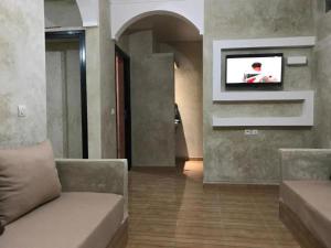 a living room with a couch and a tv on the wall at Tigmi Aftas Mirleft in Mirleft