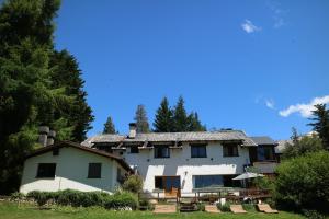 una gran casa blanca con árboles en el fondo en Hosteria Las Cartas en San Carlos de Bariloche