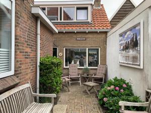 een patio met 2 banken en een tafel en stoelen bij Pollux bij Vuurtoren en strand in Noordwijk aan Zee