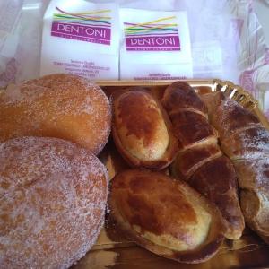 una bandeja de donuts y otros pasteles en una tienda en B&B Il Villino en Torre dell'Orso