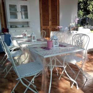 B&B Il Villino في توري ديل أورسو: طاولة بيضاء وكراسي في غرفة
