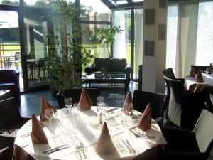 ein Esszimmer mit Tischen und Stühlen mit Servietten in der Unterkunft Hotel Les Mignees in Barvaux