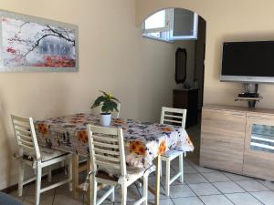 a dining room with a table and chairs and a tv at La Terrazza degli Oleandri in Stresa