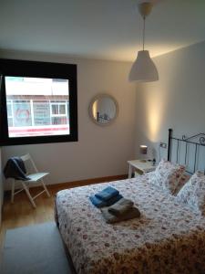 1 dormitorio con 1 cama, 1 silla y 1 ventana en Apartamento Camiño dos Faros en Ponteceso
