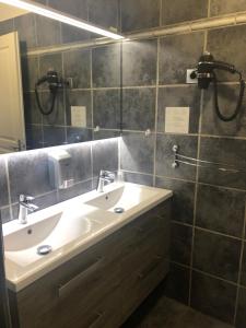 a bathroom with a sink and a mirror at Hôtel Le Lys d'Or in Vauvert