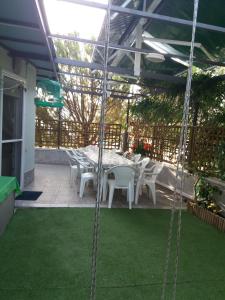 a patio with a table and white chairs on a patio at Green House in Nea Peramos