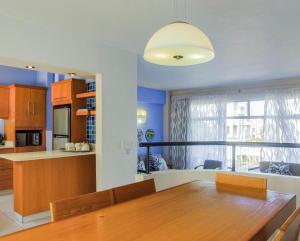 a kitchen and living room with a wooden table and a dining room at 65OnLagoonDrive 5 sleeper Self-catering Unit in Durban