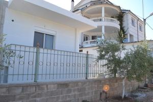 a white house with a fence in front of it at Villa Melodia Xhek in Ksamil