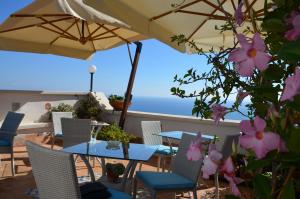 a patio with a table and chairs and an umbrella at La Soffitta Sul Mare in Vietri sul Mare