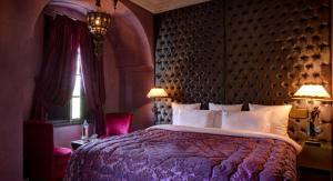 um quarto com uma cama grande e uma colcha roxa em Riad Wow em Marraquexe