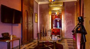 a room with a glass table and a mirror at Riad Wow in Marrakesh