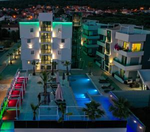 an apartment building with a swimming pool at night at Boutique Residence Cosmopolis 1 in Bibinje