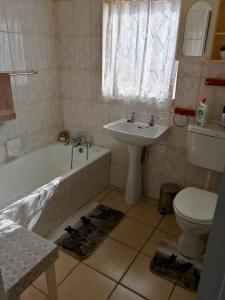 a bathroom with a sink and a tub and a toilet at Seaview on Shelly in Margate