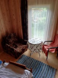 une chambre avec une table, une chaise et une fenêtre dans l'établissement Brīvdienu māja ar kopējo virtuvi, à Salacgrīva
