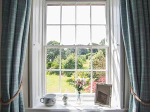 une fenêtre avec un vase de fleurs sur un rebord de fenêtre dans l'établissement Stay On The Hill - The Coach House, à Hexham