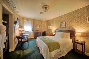 a bedroom with a bed and a desk and a chair at Inn at St John Portland In-Town in Portland