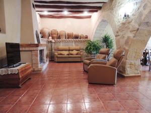 a living room with couches and a flat screen tv at Las Bodegas Del Gilo in Valdealgorfa