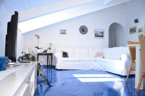 sala de estar con sofá blanco y suelo de baldosa azul en La Soffitta Sul Mare, en Vietri