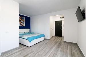 1 dormitorio con 1 cama y TV en la pared en Luxury Olimpia Studio in Bucharest, with Netflix, en Bucarest