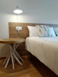 a bedroom with a bed and a table next to a bed at Iacobus VUT-CO-00371O in Padrón