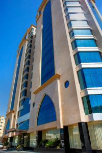 un edificio alto con ventanas azules en un lateral. en Century Hotel Doha, en Doha