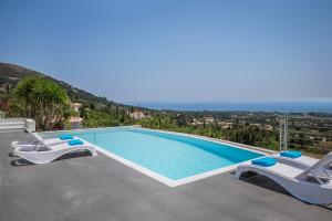 Una piscina con dos tumbonas al lado. en Countrystyle Villa Bonora, en Skala