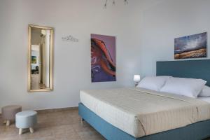 Un dormitorio con una cama grande y un espejo. en Countrystyle Villa Bonora, en Skala
