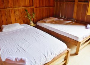 ArusíにあるPosada Hannanyのベッド2台が隣同士に設置された部屋です。