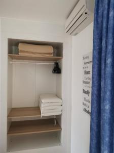 a walk in closet with wooden shelves and towels at Rainbow Golf Bungalows, Gay Men-only Resort in Maspalomas