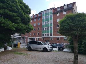 a white car parked in front of a building at City Apartment Bahnhofnah in Kiel