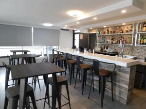 a bar with a row of stools in a restaurant at Ramada by Wyndham New Orleans in New Orleans