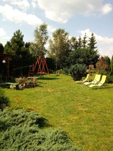 a yard with a swing set in the grass at Sloneczna Weranda in Wydminy