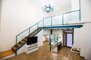 een woonkamer met een trap en een tv bij La Stella Di Ortigia in Siracusa