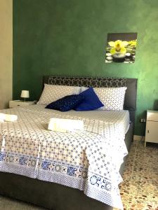 a bedroom with a large bed with blue pillows at Casa Aurora in Catania