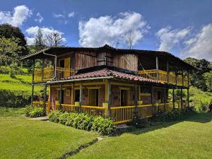 an old wooden house with a balcony on a field at La Casa Del Sol in Jardin