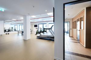 an office with a gym with treadmills and a treadmill at Hotel Vivendi in Paderborn