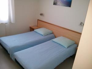 - 2 lits dans une petite chambre avec des draps bleus dans l'établissement Résidence Florimontane, à Talloires