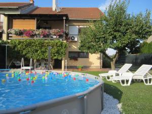 a swimming pool in a yard with chairs and a house at Apartman TIM in Osijek