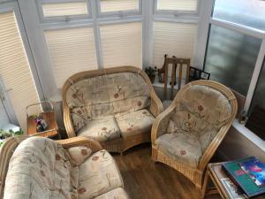 two chairs and a couch in a living room at 75ers private room in Cheltenham